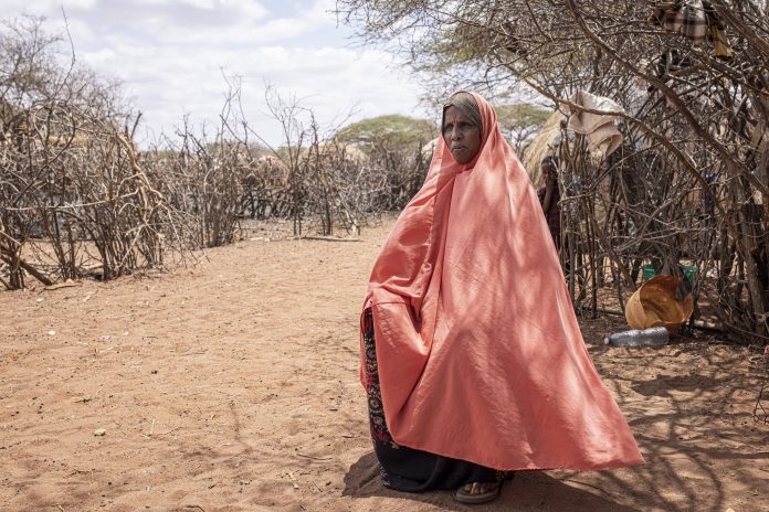 A farmer stands at her home, Saka Junction, Garissa, Kenya.