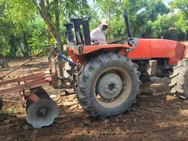 Mr Fuseini Kanton on a tractor ploughing his farm
