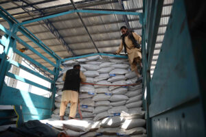 Workers moving bags of fertilizers and seeds inside a storage centre in Afghanistan.  ©FAO/Fahad Kaizer