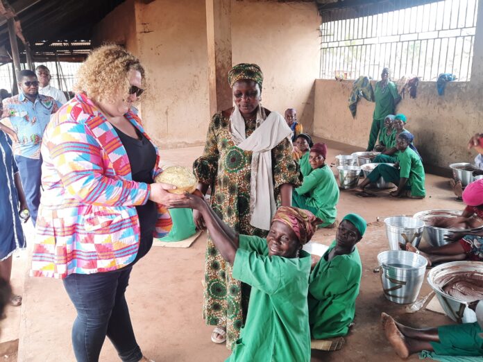 Madam Williams receiving shea butter from a representative of some of the women shea processors.