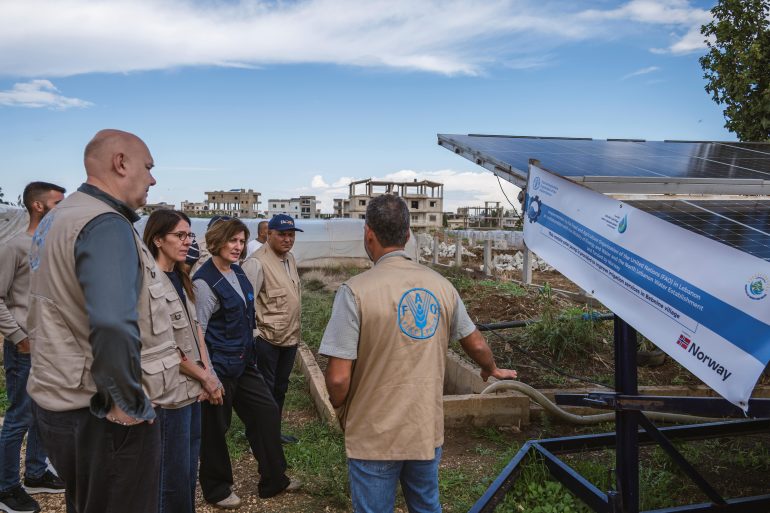 FAO Deputy Director-General Beth Bechdol (3 L), Assistant Director-General and Regional Reprsentative for the Near East and North Africa, AbdulHakim Elwaer (4 L), Director of Emergencies Rein Paulsen (L), FAO Representative in Lebanon Veronica Quattrola (2 L) stand next to the solar array during a field visit in Lebanon to meet a group of farmers who are using an innovative shared solar-powered irrigation pump to irrigate their greenhouses. ©FAO/ Ralph Azar